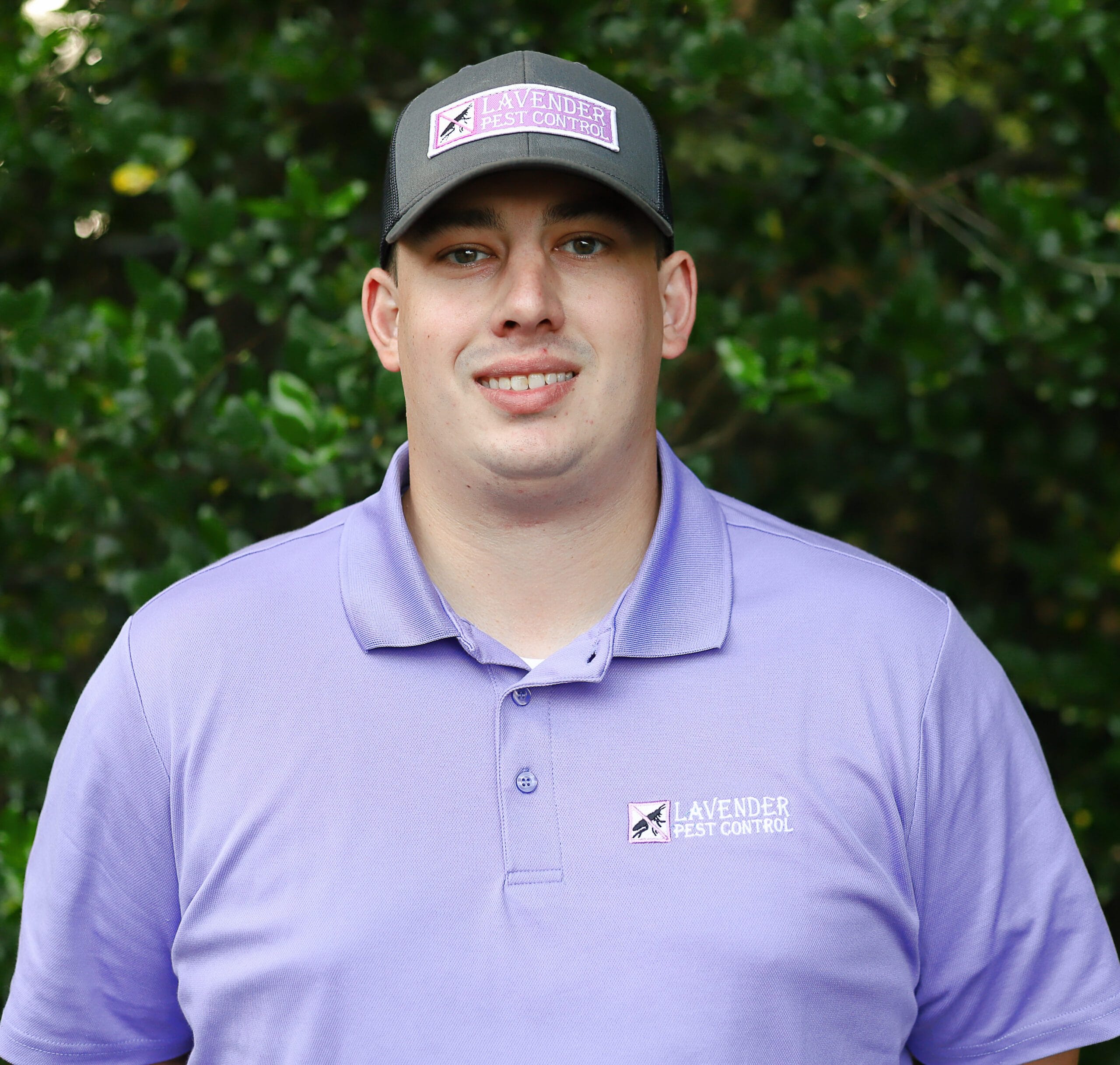Man in purple polo shirt and cap outdoors