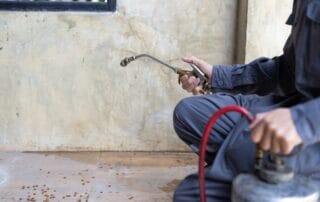Pest control worker spraying insecticide on floor